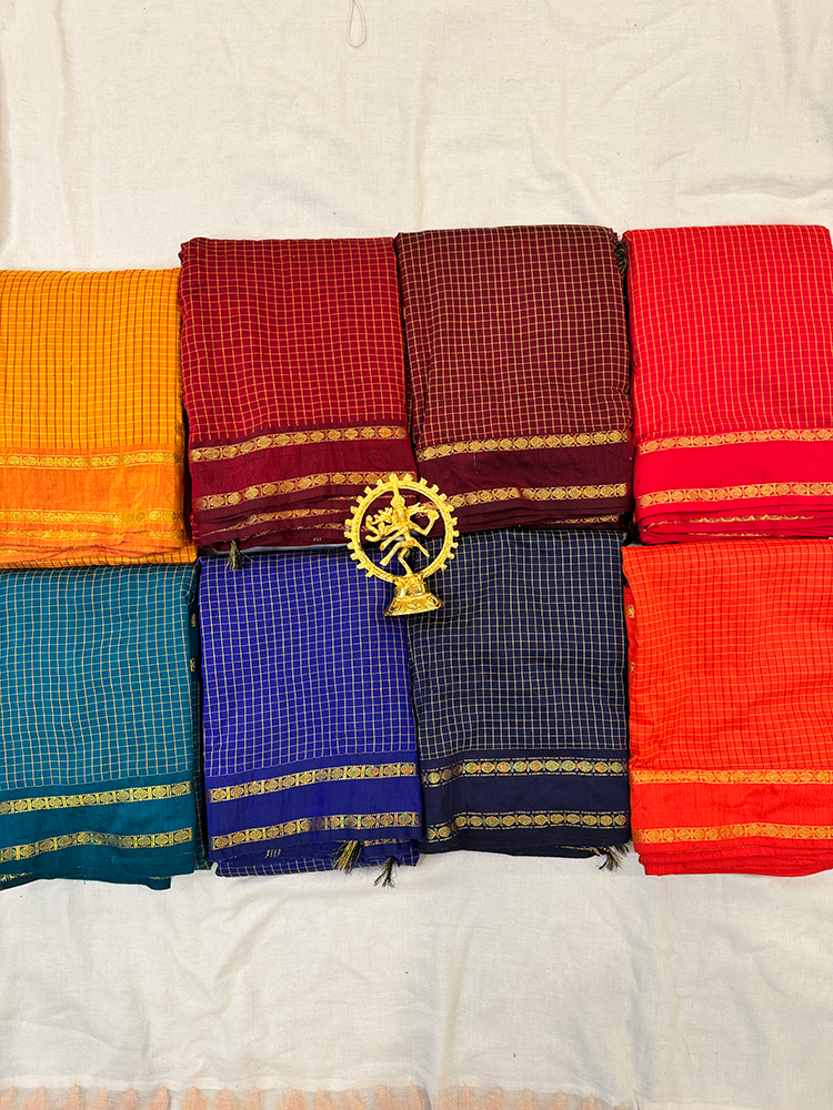 Set of colorful sarees with a central decorative item on a white background