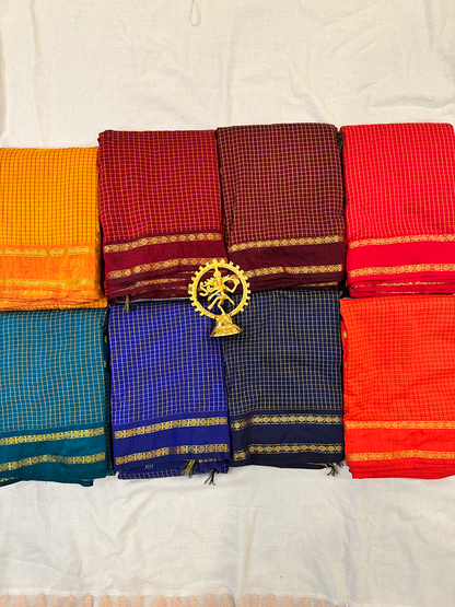 Set of colorful sarees with a central decorative item on a white background