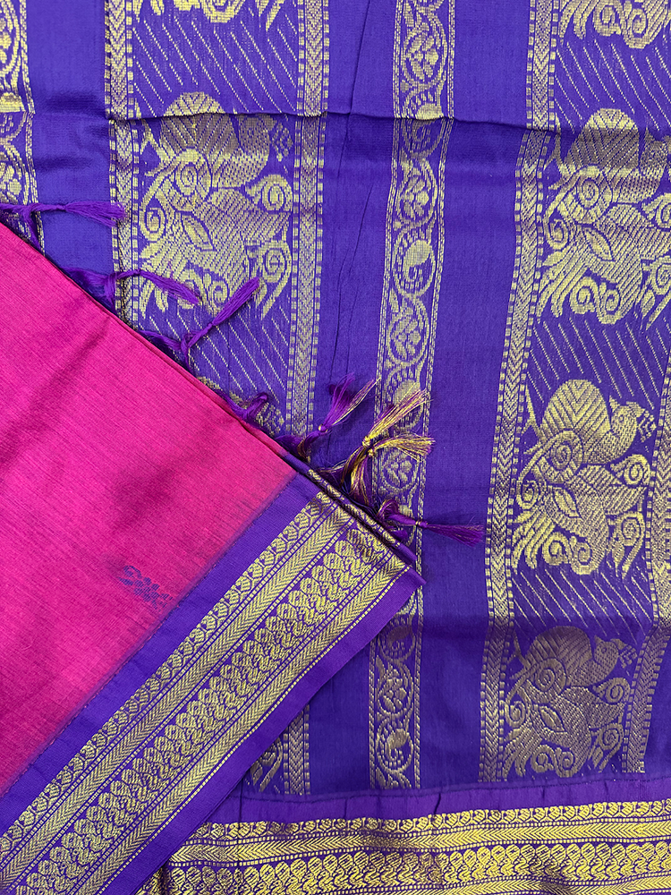 Magenta kalyani silk cotton saree with gold peacock patterns on a white background