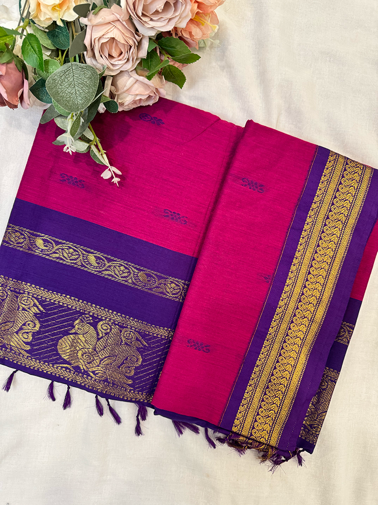 Magenta kalyani silk cotton saree with gold peacock patterns on a white background